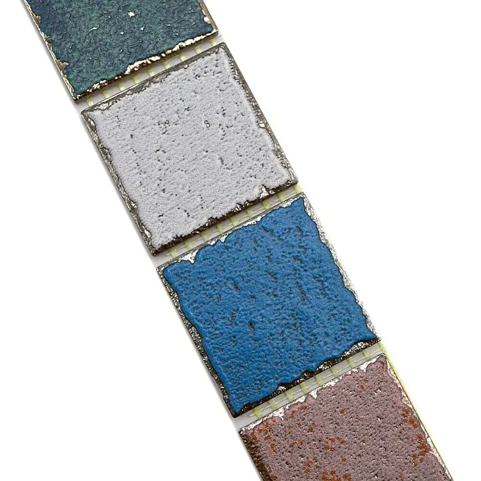 Fliesenbordüre Orient Color YBO CDCUBIS - 5 x 31,6 cm, Bunt, Matt - Nahaufnahme von farbigen Keramikfliesen, die auf einer Oberfläche aneinandergereiht sind und eine strukturierte Oberfläche haben.
