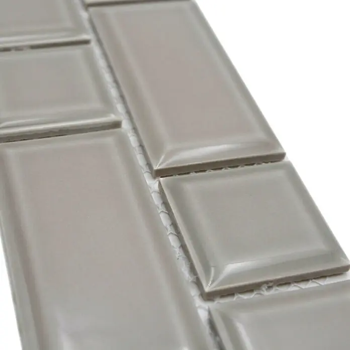 Fliesenbordüre Uni YBO M04CM - 4,5 x 29,4 cm, Grau, Glänzend - Nahaufnahme von glänzenden, hellgrauen Wandfliesen in verschiedenen Formaten, die ein elegantes und modernes Design für Innenräume bieten.