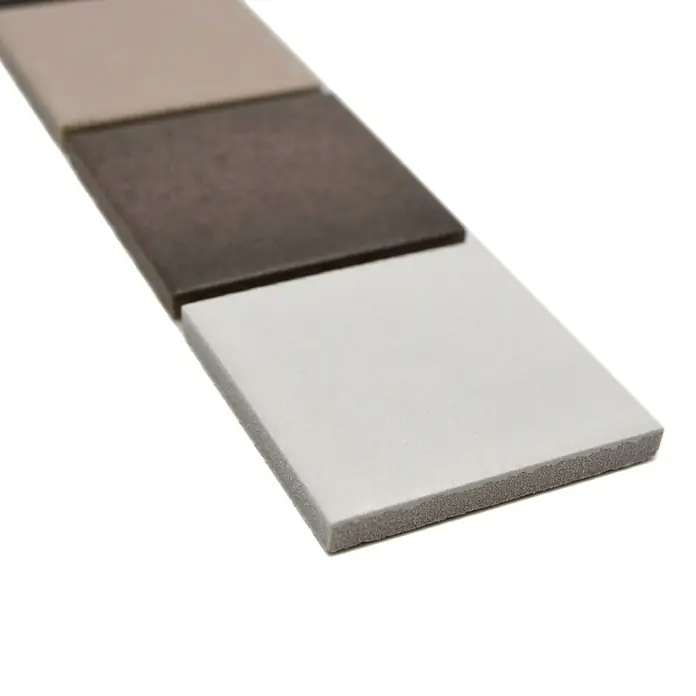 Fliesenbordüre YBO CD218 - 4,8 x 30,6 cm, Mix Grau, Matt - Nahaufnahme von quadratischen Keramikfliesen in verschiedenen Farbtönen, die eine Palette von Beige bis Dunkelbraun zeigen.