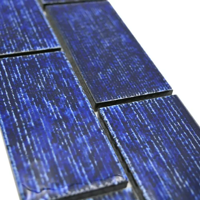Fliesenbordüre YBO KAS6 - 4,7 x 29,7 cm, Blau, Glänzend - Nahaufnahme von dunkelblauen rechteckigen Mosaikfliesen mit subtilen weißen Maserungen für stilvolle Wand- oder Bodengestaltung.