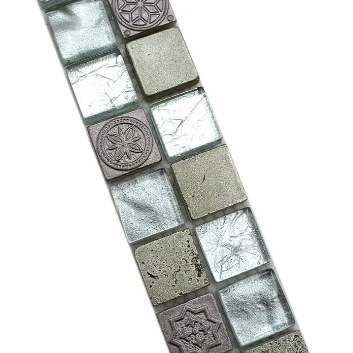Fliesenbordüre YBO CB33 - 30 x 4,8 cm, Mix Silber, Glänzend - Nahaufnahme eines Musters aus quadratischen Mosaikfliesen in Silber- und Grautönen mit dekorativen floralen Akzenten.