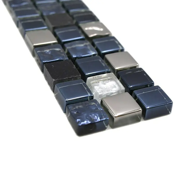 Fliesenbordüre YBO M660 - 30 x 4,8 cm, Mix Schwarz/Silber, Glänzend - Nahaufnahme eines Musters von schimmernden blauen, silbernen und klaren Mosaikfliesen auf einer weißen Oberfläche.