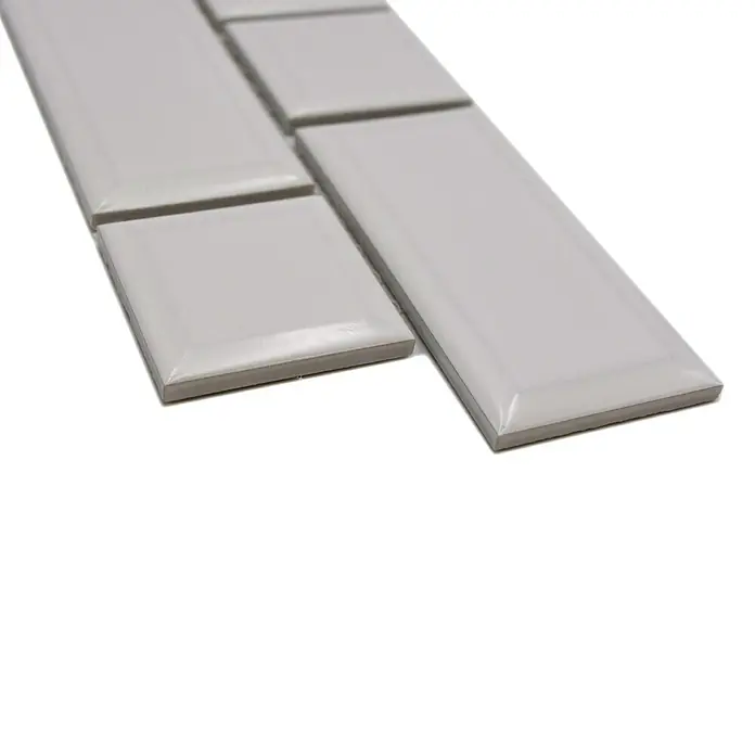 Fliesenbordüre Uni YBO M06PM - 4,5 x 29,4 cm, Weiß, Glänzend - Nahaufnahme von hellgrauen, glänzenden Keramikfliesen in verschiedenen Formaten, die ein elegantes und modernes Designelement darstellen.