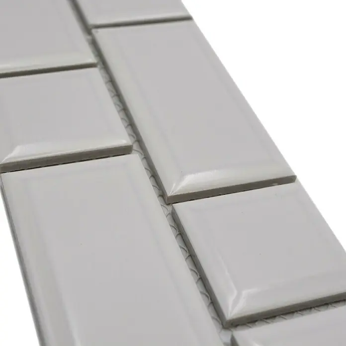 Fliesenbordüre Uni YBO M06PM - 4,5 x 29,4 cm, Weiß, Glänzend - Nahaufnahme von weißen, rechteckigen Keramikfliesen mit abgeschrägten Kanten, die ein elegantes und modernes Design zeigen.