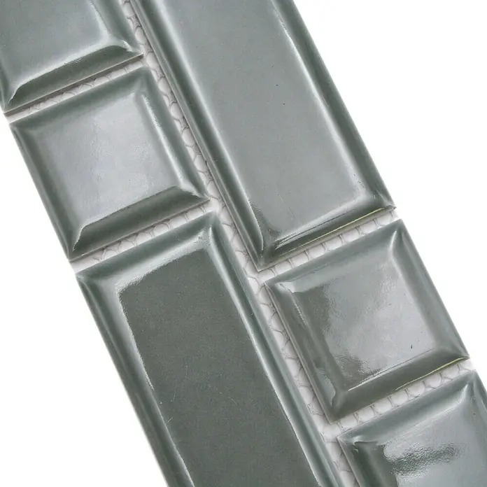 Fliesenbordüre Uni YBO M06PM - 4,5 x 29,4 cm, Petrol, Glänzend - Nahaufnahme von glänzenden, grauen Keramikfliesen mit rechteckigen und quadratischen Formen für stilvolle Wandgestaltung.
