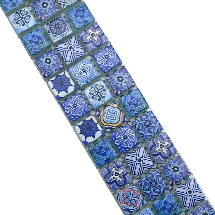 Fliesenbordüre YBO RB33 - 30 x 4,8 cm, Blau, Glänzend - Nahaufnahme eines Musters aus blauen quadratischen Glasmosaikfliesen mit verschiedenen Motiven.