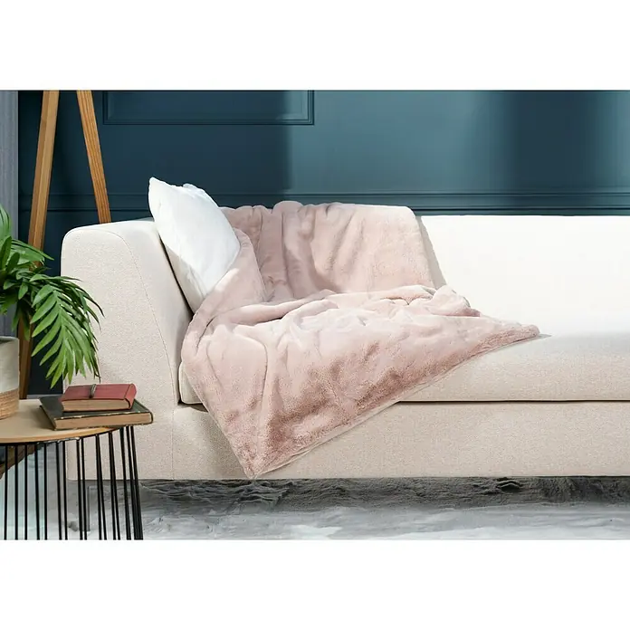 Decke Happy - Puderrosa, 200 x 150 cm, 100 % Polyester - Kuscheliges, rosafarbenes Fellimitat auf einem hellen Sofa mit Kissen und Beistelltisch. Ideal für gemütliche Stunden und als stilvolles Wohnaccessoire.