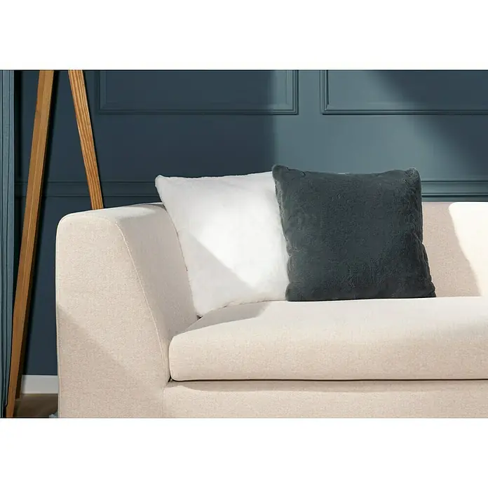 Kissen Happy - Elfenbein, 48 x 48 cm, 100 % Polyester - Nahaufnahme eines beigen Sofas mit einem weißen und einem grauen dekorativen Kissen, die dem Wohnraum eine gemütliche Note verleihen.