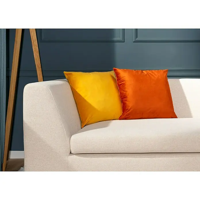 Kissen Finja - Golden Glow, 45 x 45 cm, 100 % Polyester - Zwei dekorative Kissen, ein gelbes und ein orangefarbenes, liegen auf einem eleganten, cremefarbenen Sofa. Stimmungsvolles Ambiente für Ihr Zuhause.