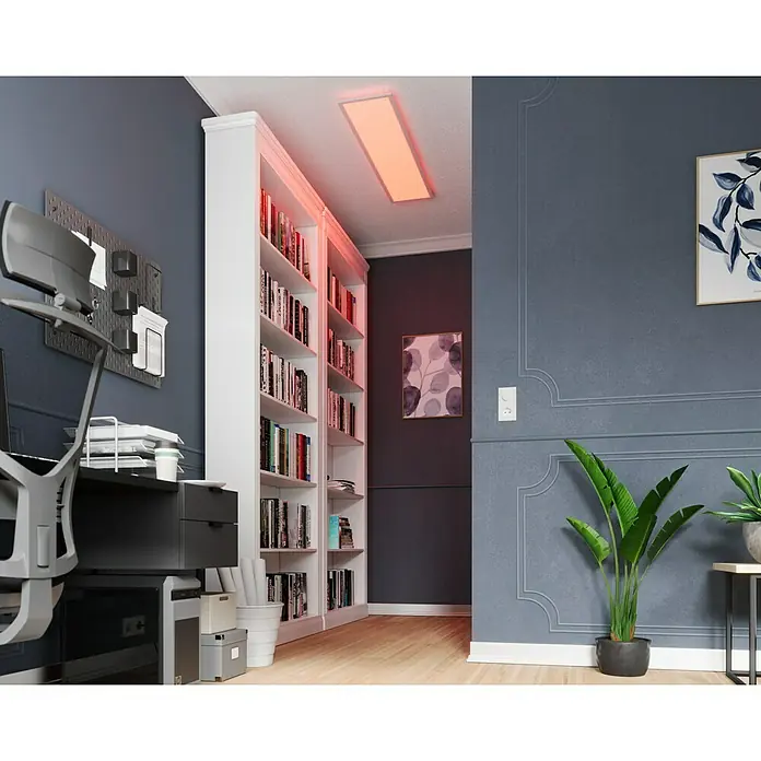 Tween Light LED-Panel RGB-RC-CCT-DIM - 32,5 W, L x B x H: 120 x 30 x 5,5 cm, Weiß, RGBW - Das Bild zeigt ein modern gestaltetes Büro mit einem großen Bücherregal und einer roten LED-Deckenleuchte.