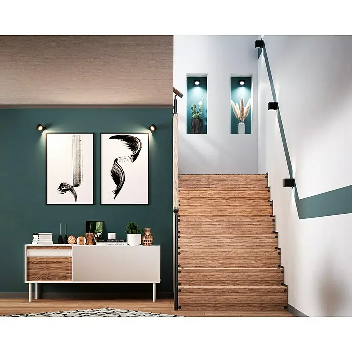 swingcolor Latexfarbe - Schneeweiß, Seidenglänzend, 1 l, Konservierungsmittelfrei - Ein stilvolles Interieur mit einer modernen Kommode, abstrakten Kunstwerken und einer eleganten Holztreppe mit minimalistischen Leuchten.