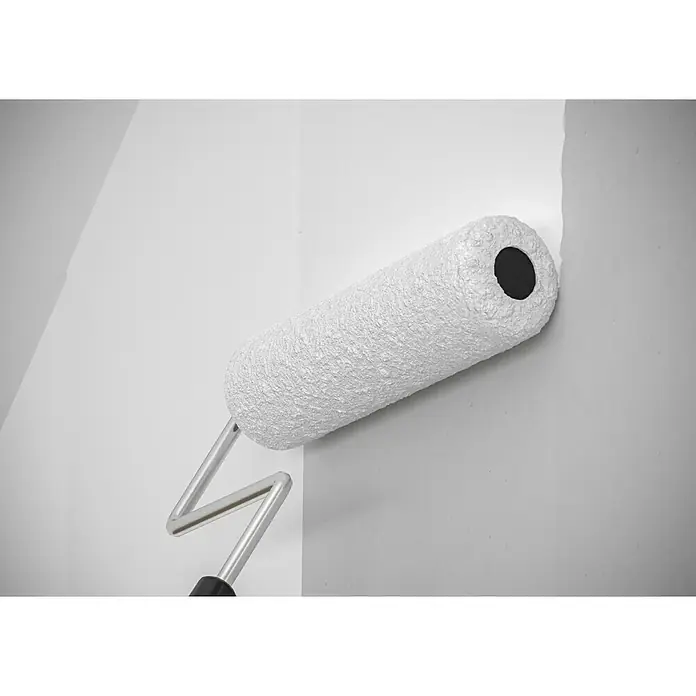 swingcolor Wandfarbe Wand- & Deckenfarbe - Weiß, Matt, 10 l, Konservierungsmittelfrei - Nahaufnahme einer weißen Farbwalze, die eine Wand streicht. Das Werkzeug ist sauber und einsatzbereit für Renovierungsarbeiten im Haus.