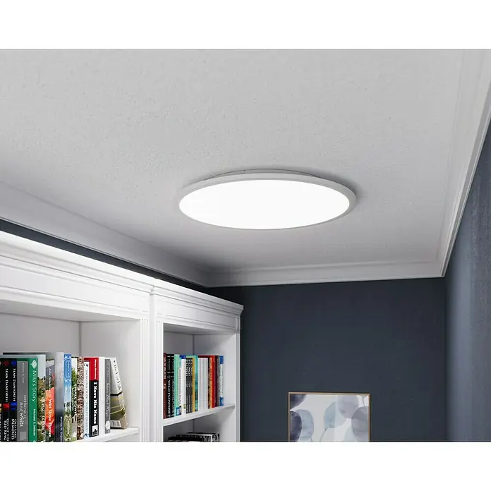 Tween Light LED-Panel rund RC-CCT-DIM - 35 W, Ø x H: 60 x 5 cm, Weiß, Mehrfarbig - Deckenleuchte mit runder Form und schlichtem Design, ideal für moderne Innenräume mit Bücherregal und blauer Wand.
