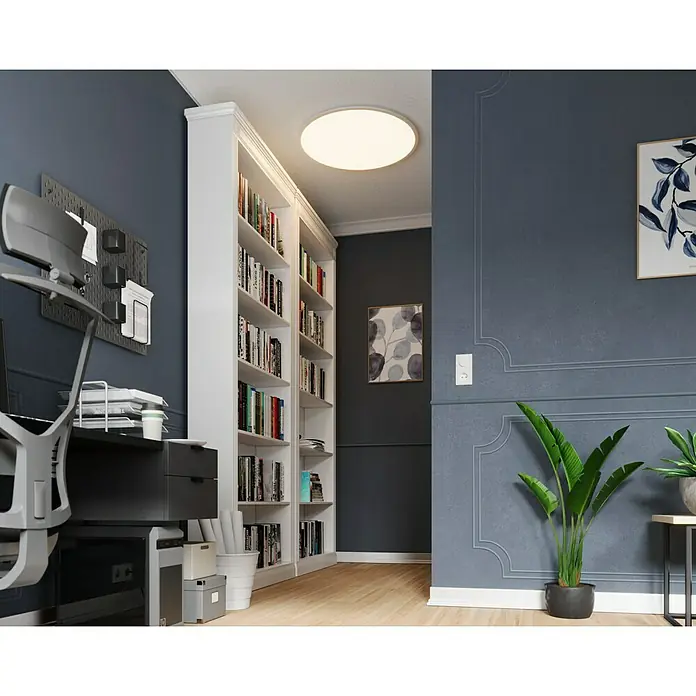 Tween Light LED-Panel rund RC-CCT-DIM - 41 W, Ø x H: 80 x 5 cm, Weiß, Mehrfarbig - Ein modernes Arbeitszimmer mit einem großen weißen Bücherregal und einem hellen Deckenlicht. Der Raum ist in dunklen Blautönen gehalten.