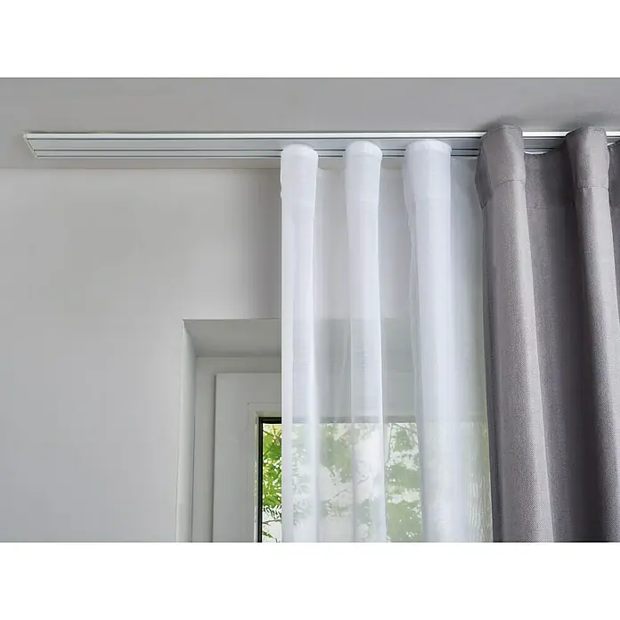 Vorhangschiene Level Verdunkelungssystem - Weiß, Länge: 150 cm, Anzahl Läufe: 3 Stk. - Nahaufnahme einer Gardinenschiene mit weißen und grauen Vorhängen. Ideal für die Fensterdekoration und zur Verdunkelung von Räumen.