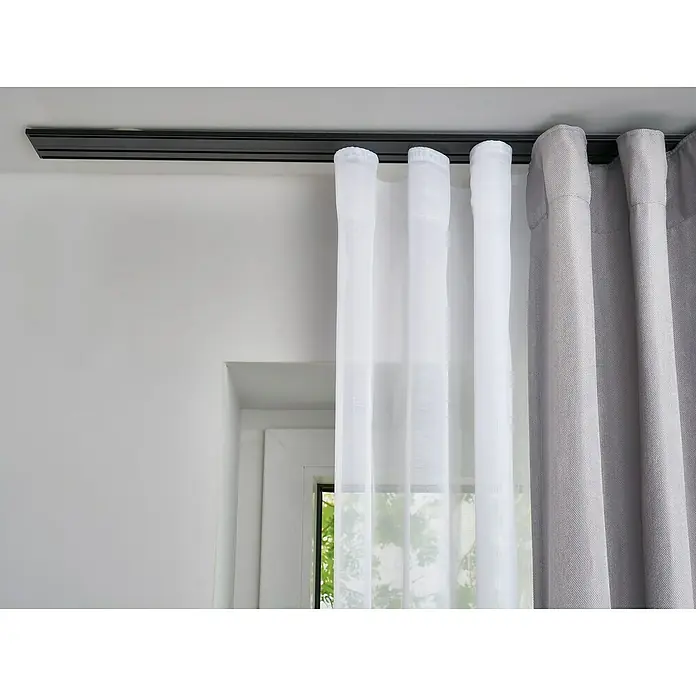 Vorhangschiene Level Verdunkelungssystem - Schwarz, Länge: 200 cm, Anzahl Läufe: 3 Stk. - Nahaufnahme eines Fensters mit eleganten, transparenten weißen Vorhängen und blickdichten grauen Gardinen, die an einer schwarzen Vorhangschiene hängen.