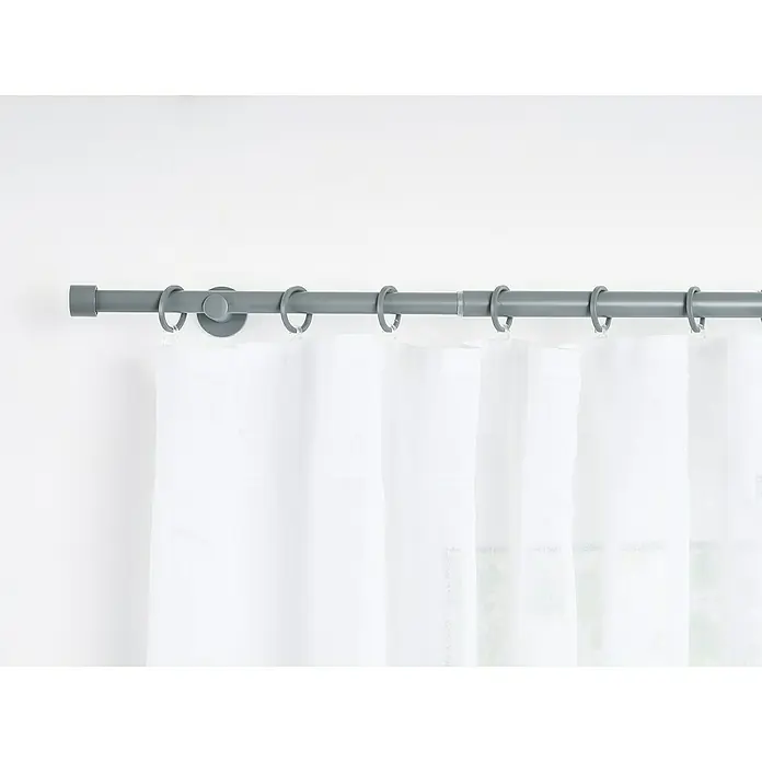 Stilgarnitur Cosy - Dark Grey, Auszugslänge: 160 cm - 280 cm - Eine graue Gardinenstange mit weißen Vorhängen. Die Stange ist an einer weißen Wand montiert und hängt elegant herunter.