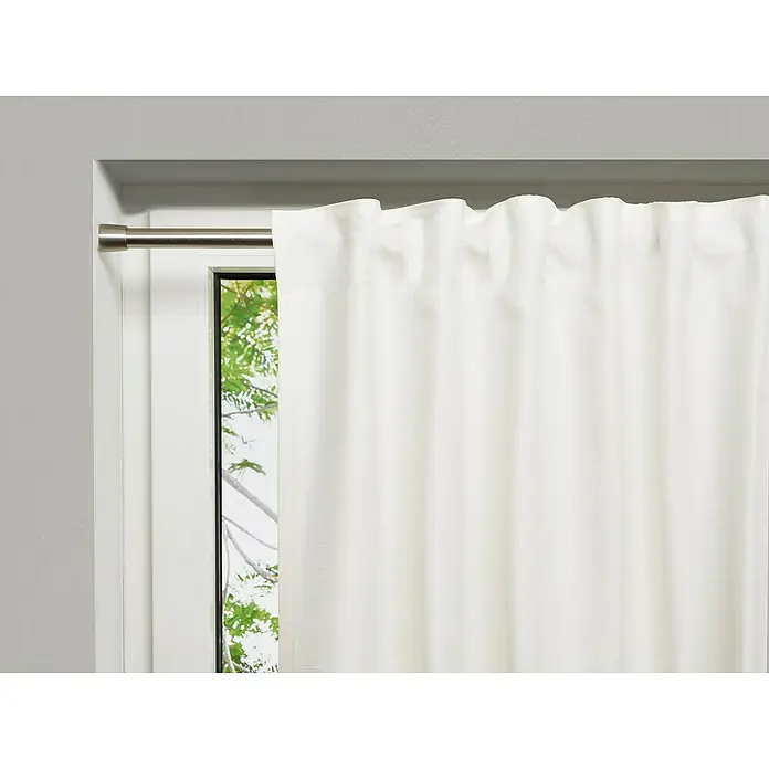 Spannstange Stretch - Edelstahl-Optik, Auszugslänge: 120 cm - 220 cm - Nahaufnahme eines weißen Verdunkelungsvorhangs an einer Gardinenstange vor einem Fenster.