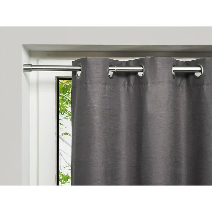 Spannstange Stretch - Edelstahl-Optik, Auszugslänge: 120 cm - 220 cm - Grauer Verdunkelungsvorhang mit Ösenaufhängung an einer silbernen Gardinenstange vor einem Fenster.