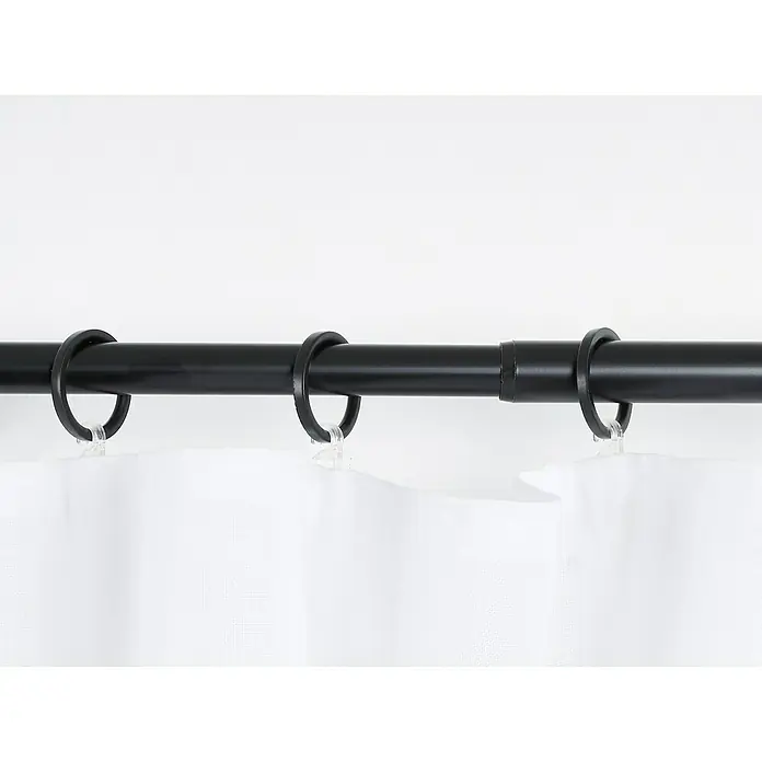 Stilgarnitur Cosy - Black, Auszugslänge: 120 cm - 210 cm - Nahaufnahme einer schwarzen Gardinenstange mit Ringen und durchscheinendem Stoff. Ideal für Fensterdekorationen und zur Lichtsteuerung im Raum.
