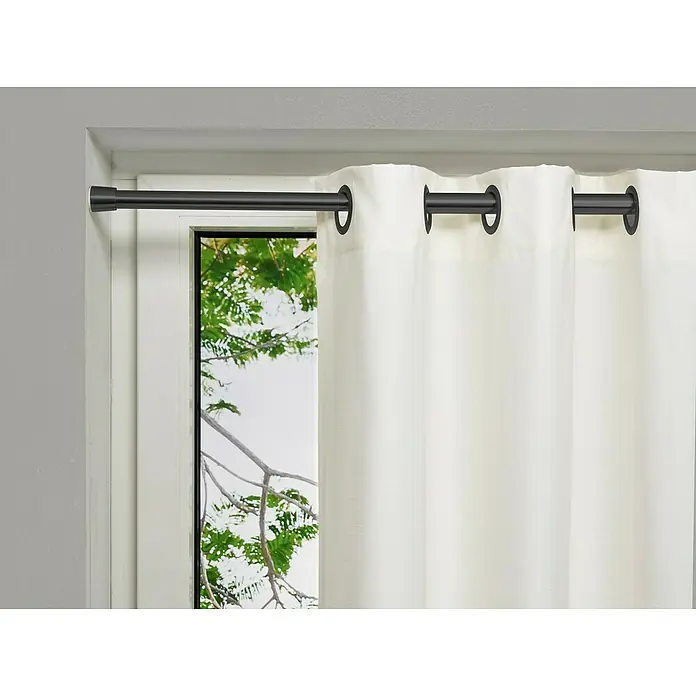 Spannstange Stretch - Schwarz, Auszugslänge: 80 cm - 130 cm - Nahaufnahme einer schwarzen Gardinenstange mit weißen Vorhängen und einem Fenster mit Blick auf grüne Bäume.