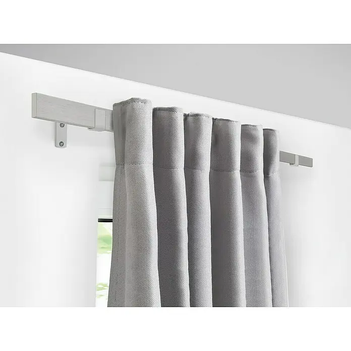 Stilgarnitur Up Right - Länge Gardinenstange: 160 cm - 280 cm, Edelstahl-Optik - Graue Vorhänge hängen an einer grauen Gardinenstange und sorgen für Privatsphäre und ein stilvolles Ambiente im Raum.