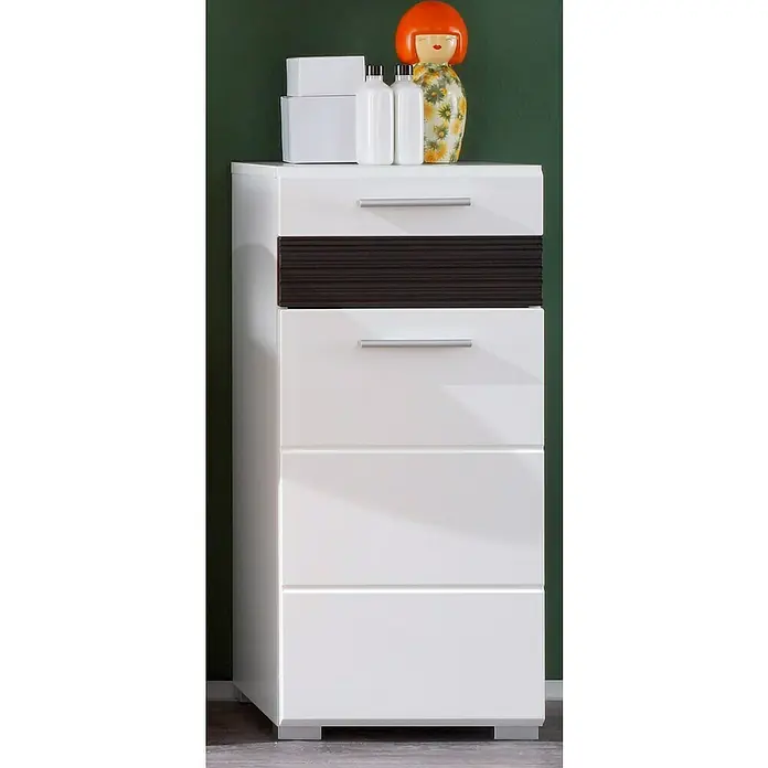 Trendteam Mezzo Unterschrank - 37 x 31 x 79 cm, Weiß/Melinga Dark Oak - Das Bild zeigt eine moderne, weiße Kommode mit vier Schubladen, wobei die zweite Schublade ein braunes, geriffeltes Design aufweist. Oben stehen Dekoartikel.