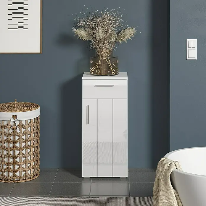 Trendteam Wons Unterschrank - 37 x 31 x 83 cm, Weiß - Ein weißer Badezimmerschrank mit Schublade und Tür, dekoriert mit einer Vase mit Trockenblumen.