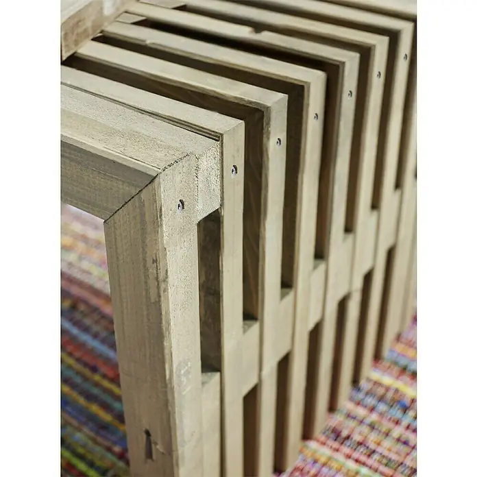 Plus Gartenbank RustikB x T x H: 138 x 49 x 45 cm, Nadelholz, Natur - Detailaufnahme eines hellen Holzregals mit wiederholenden rechteckigen Formen und sichtbaren Schrauben, das auf einem farbenfrohen Teppich steht.
