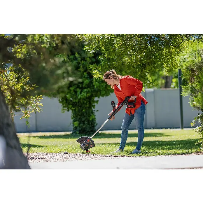 Ducati Recortabordes de batería DGT401L - 40 V, 2,5 Ah, Iones de litio, Sin batería, Ancho de corte hilo: 30 cm - Mujer usando un cortabordes de la marca Worx en el jardín. La herramienta es inalámbrica y funciona con batería para jardinería flexible.