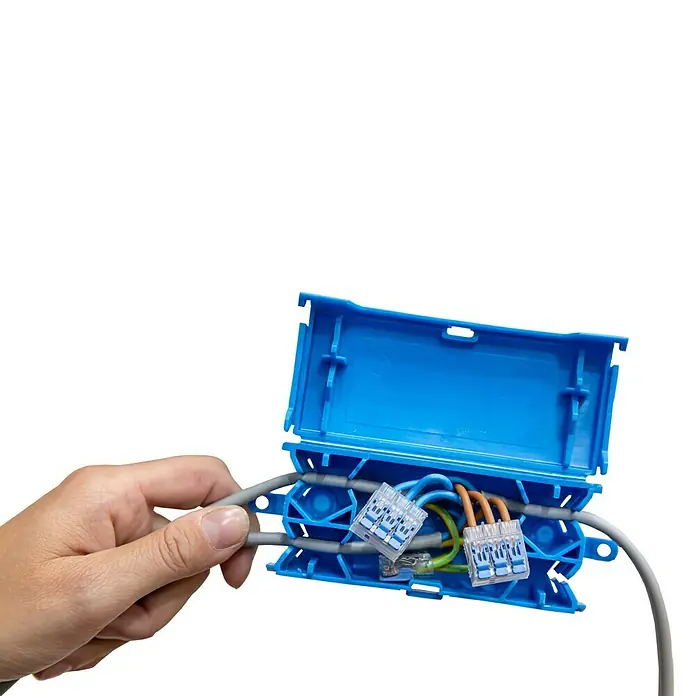 Ideal Hebelklemme Gen II - Anzahl Leiter: 2 Stk., 4 mm², 40 Stk. - Eine blaue Verteilerdose mit Kabeln und Klemmen, gehalten von einer Hand, die die Installation oder Reparatur elektrischer Verbindungen demonstriert.