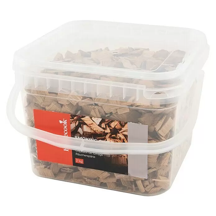 Barbecook Räucherspäne - 2 kg, Eiche Whisky - Transparenter Plastikeimer gefüllt mit hellbraunen Holz-Räucherchips mit rotem Etikett.