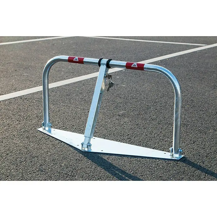 Schake Sperrbügel - L x B x H: 850 x 33,7 x 450 mm, Stahl, Aufdübeln, Profilzylinderschloss - Absperrbügel aus Metall auf einem Parkplatz. Der Parkbügel schützt den Parkplatz vor unbefugtem Parken und ist mit einem Schlüssel gesichert.