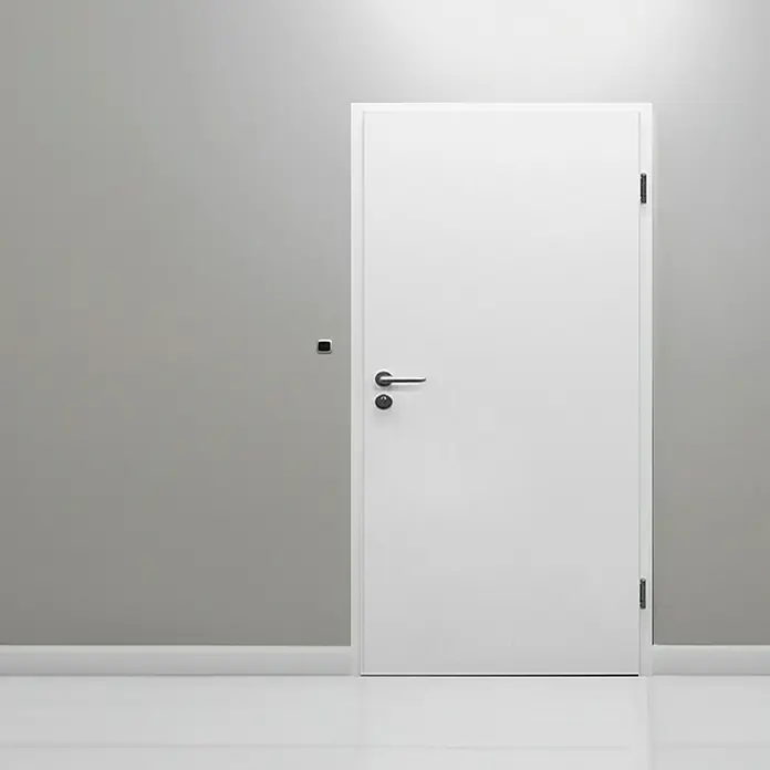 Invado Wohnungseingangstür FT1 - Klimaklasse nach RAL: II, 860 x 1.985 mm, DIN Anschlag: Rechts, Verkehrsweiß matt - Eine moderne, weiße Innentür mit elegantem Griff in einem minimalistischen Raum, ideal für moderne Wohnkonzepte.