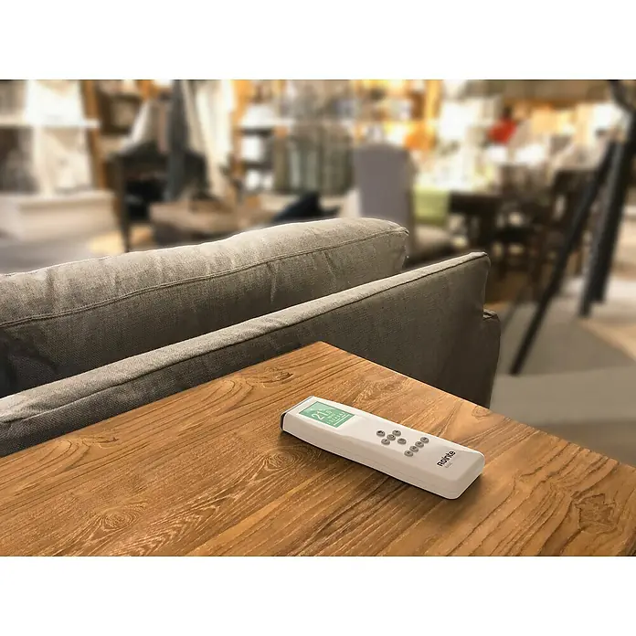 Rointe Mando a distancia Basic Control - Blanco - Primer plano de un mando a distancia Romte blanco sobre una mesa de madera, que combina comodidad y tecnología moderna.