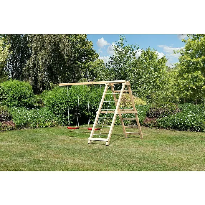 Karibu Kinderspielturm Fidel - L x B x H: 243 x 198 x 329,5 cm, Terragrau, Mit roter Rutsche & Klettergerüst - Ein hölzernes Schaukelgerüst mit zwei roten Schaukeln steht auf einem grünen Rasen vor üppigem Grün.