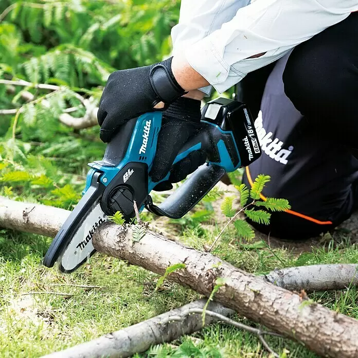 Makita LXT 18V Akku-Astsäge DUC101RF01 - 18 V, 3 Ah, 1 Akku - Person schneidet einen Ast mit einer blau-schwarzen Makita Akku-Kettensäge.