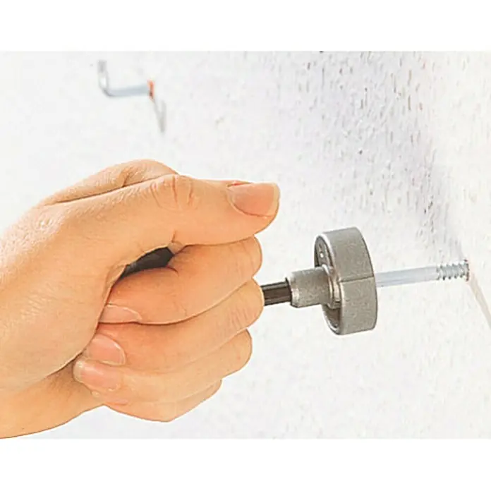 Wolfcraft Hakenschraubendreher - Passend für: Hakenschrauben max. 6 mm Kopfbreite, Ringschrauben max. 6 mm Kopfbreite - Eine Hand fixiert eine Schraube mit einem Schraubwerkzeug in einer Wand. Ideal für Heimwerkerprojekte und Reparaturen im Haushalt.