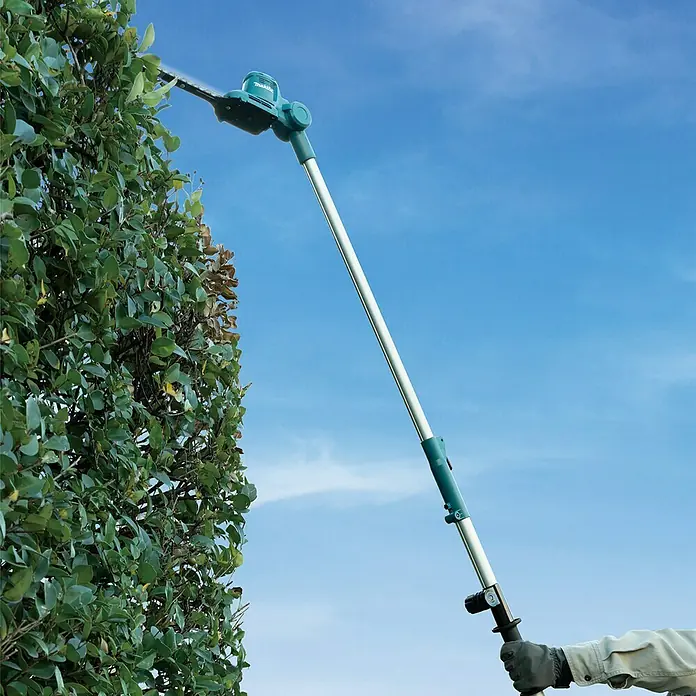 Makita CXT 12V max. Teleskop-Heckenschere UN460WDZ - Li-Ionen, Anzahl Akkus: Ohne Akku, Schnittlänge: 46 cm - Die Makita Akku-Heckenschere wird beim Heckenschneiden vor einem blauen Himmel verwendet.