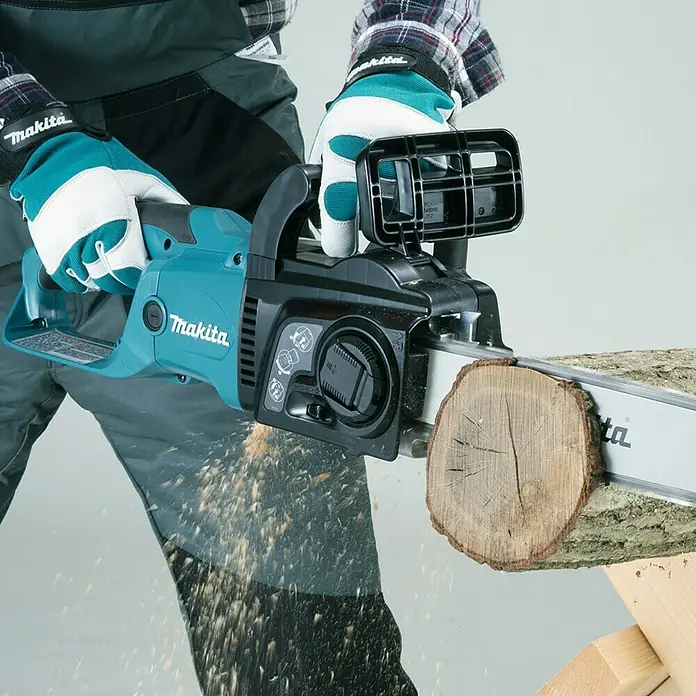 Makita Elektro-Kettensäge UC3551AK - 2.000 W, Schwertlänge: 35 cm - Eine Makita Akku-Kettensäge im Einsatz beim Schneiden eines Baumstamms, gut geeignet für Gartenarbeiten.