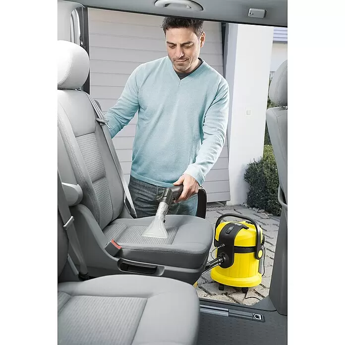 Kärcher Lava-aspirador SE 4002 - 1.400 kW, Volumen de recipiente: 4 l - Hombre limpiando un asiento de coche con una aspiradora de inyección-extracción Kärcher amarilla.