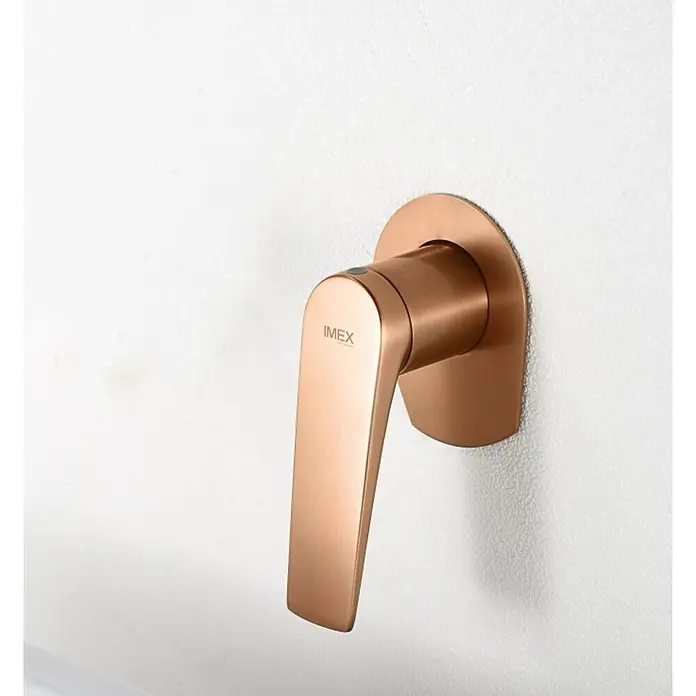 Imex Delos Grifo de lavabo - Oro rosa - Un moderno grifo IMEX de oro rosa montado en una pared blanca. Diseño elegante para cualquier baño.