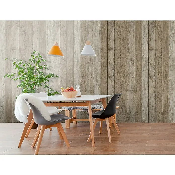 Bariperfil Revestimiento de pared de PVC Floral Wood - 260 x 33,3 cm, Floral Wood - Una mesa de comedor con sillas se encuentra frente a una pared de paneles de madera con una lámpara colgante amarilla y blanca. La mesa está decorada con fruta.