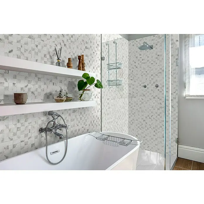 Bariperfil Revestimiento de pared de PVC Marmólico - 260 x 33,3 cm, Marmolico - Elegante baño con azulejos de mosaico, estantes blancos y bañera exenta. El foco está en la bañera elegante con accesorios.