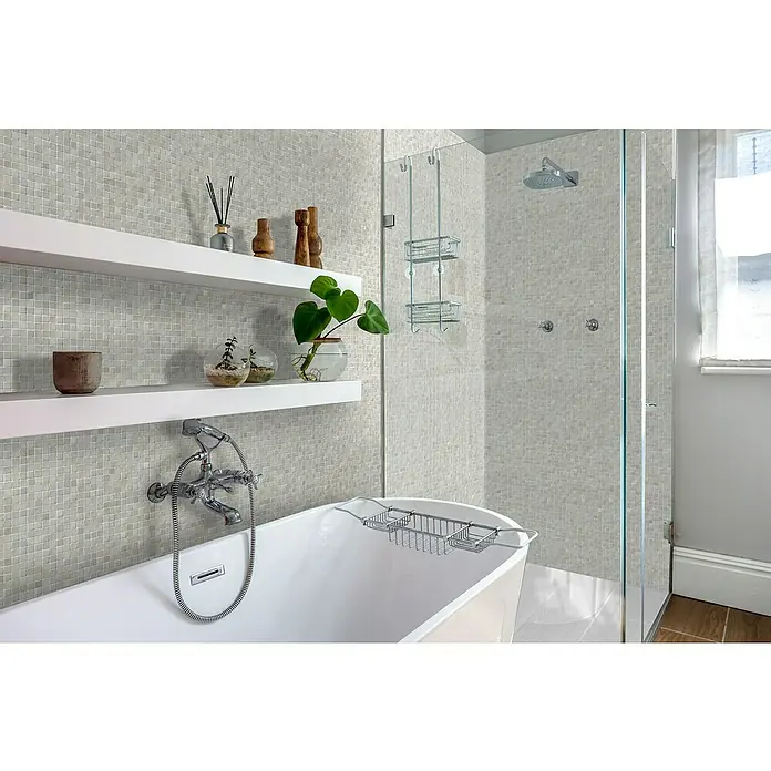 Bariperfil Revestimiento de pared de PVC Nacar Tile - 260 x 33,3 cm, Nacar - Elegante baño con azulejos de mosaico, bañera exenta y estantes blancos que exhiben accesorios elegantes. La cabina de ducha completa el diseño moderno.