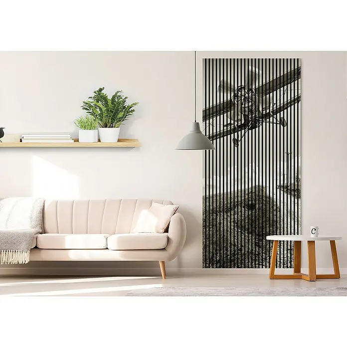 Akustikpaneel - L x B x H: 2.400 x 1.133 x 19 mm, Schwarz/Weiß, Flieger 02 - Das Bild zeigt ein modernes Wohnzimmer mit einem stilvollen Wandbild mit einem Flugzeugmotiv, das durch vertikale Streifen hervorgehoben wird.