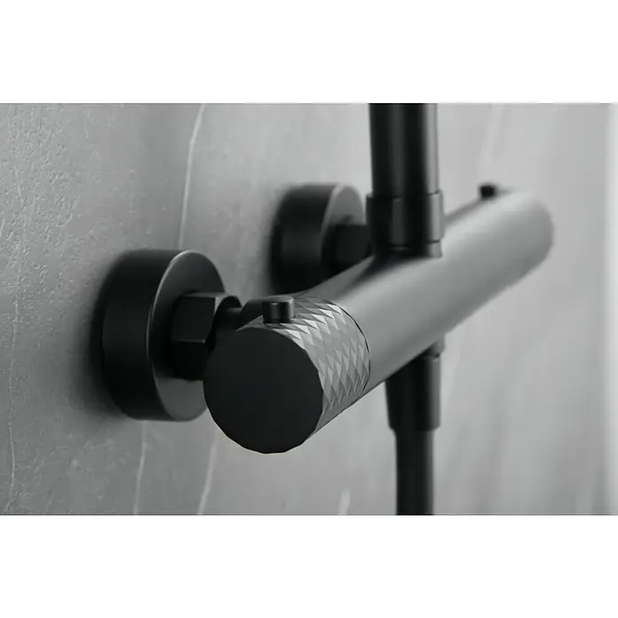 Imex Génova Sistema de ducha - Grifo termostático, Negro - Primer plano de un grifo de ducha negro montado en la pared. Cuenta con un diseño moderno y elegante con una empuñadura moleteada.