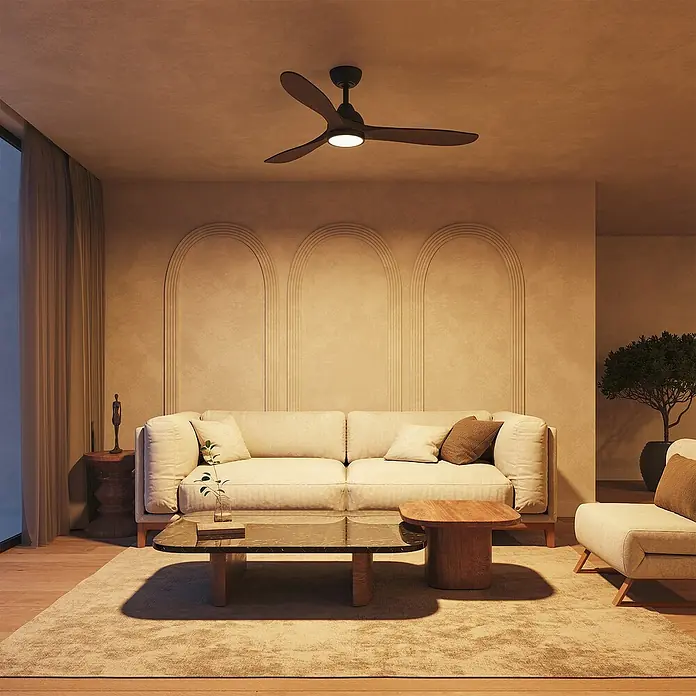 Arte confort Ventilador de techo Kenia - Roble negro, 132 cm, 34 W, Blanco cálido - El moderno ventilador de techo marrón con luz se muestra en una cálida sala de estar con muebles beiges y detalles de estuco en la pared.