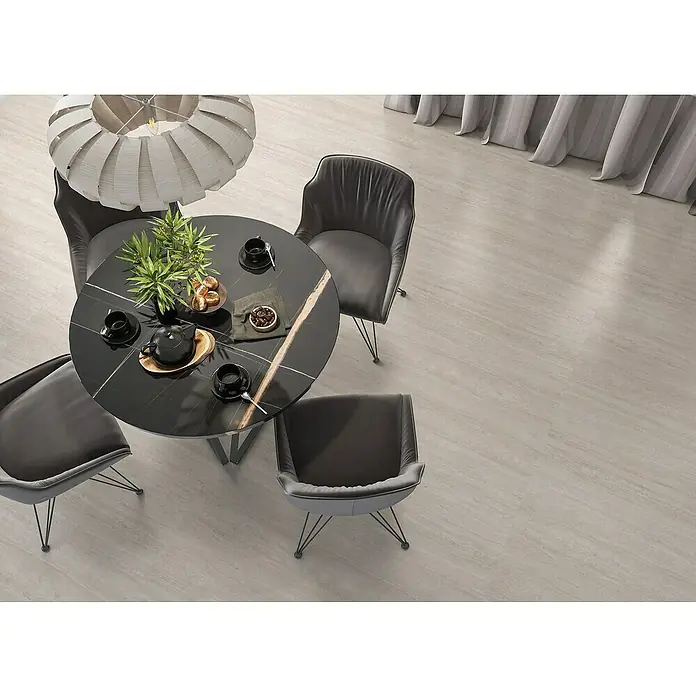 Halcón Pavimento porcelánico Pantheon - 60 x 120 cm, Album, Mate, Espesor: 7,4 mm - Mesa de comedor con cuatro sillas, tetera, tazas y pasteles bajo una lámpara moderna, creando un ambiente elegante y acogedor.