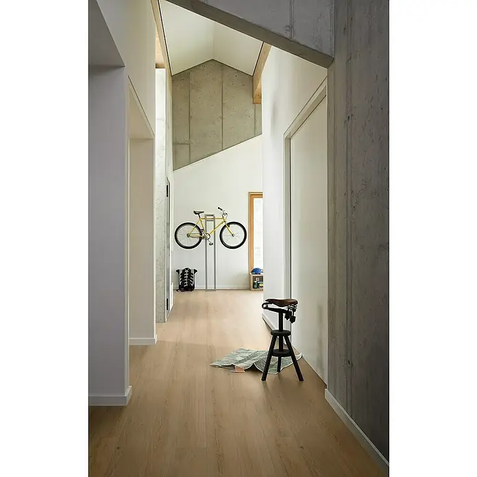 Parador Vinylbodenmuster Basic 5.3 Eiche Studioline geschliffen - 200 x 225 x 5,3 mm, Landhausdiele - Helle, moderne Fluransicht mit einem Fahrrad, einem Hocker und einem Holzboden, die eine einladende und stilvolle Atmosphäre schafft.